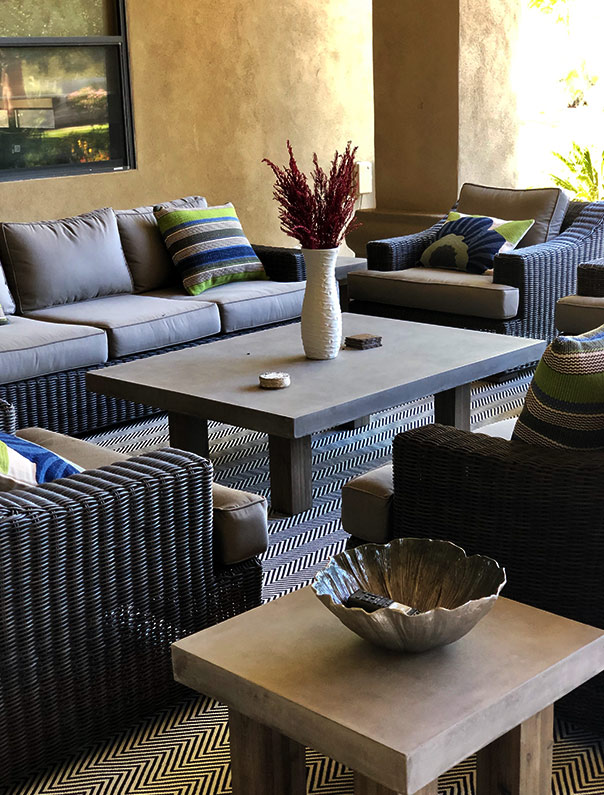 Outdoor wicker seating area with concrete tables
