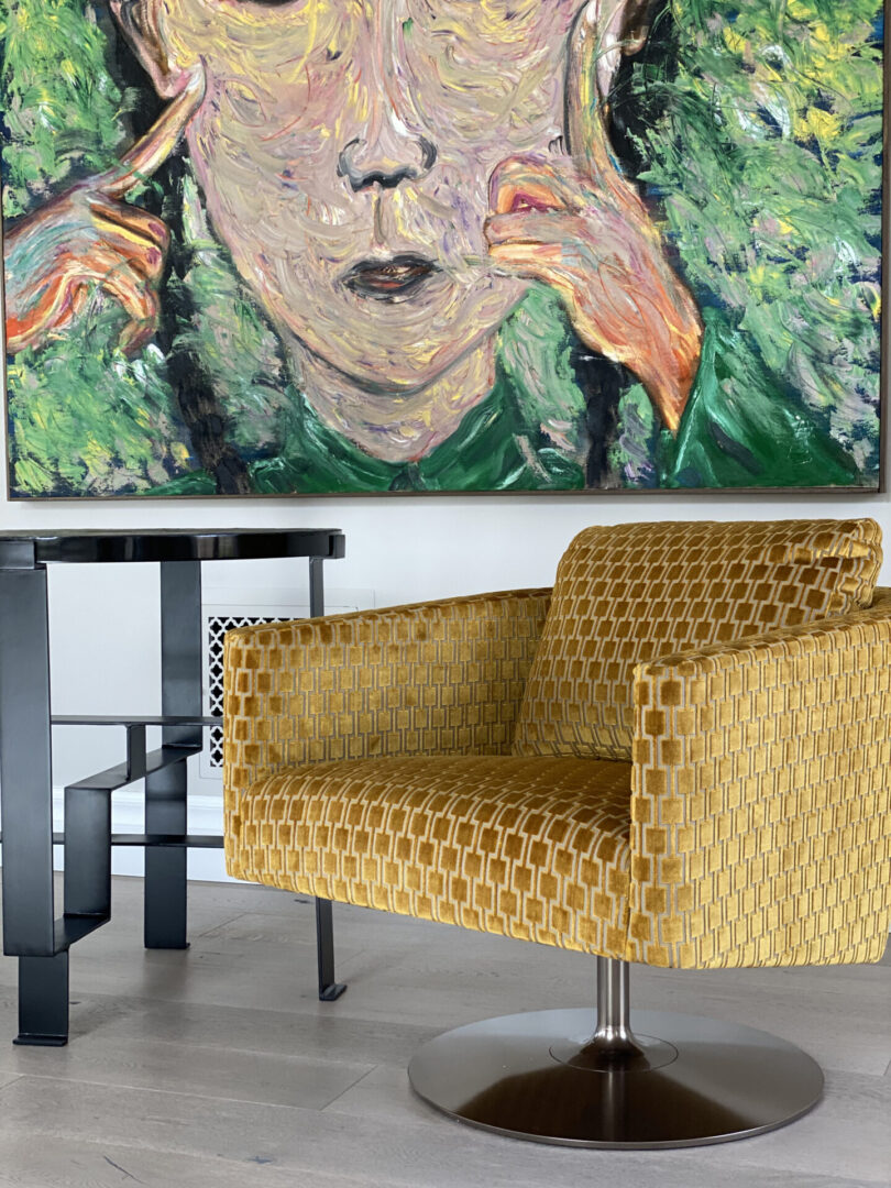 Yellow patterned swivel chair beneath abstract face painting