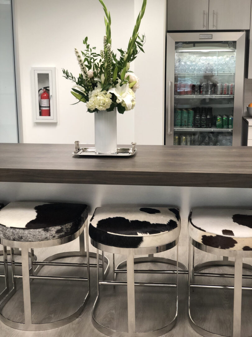 Vase of flowers on counter with cowhide stools