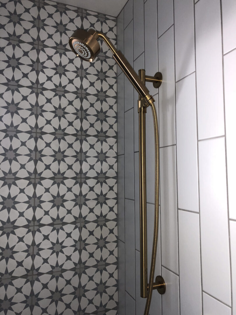 Brass shower head with patterned tile wall