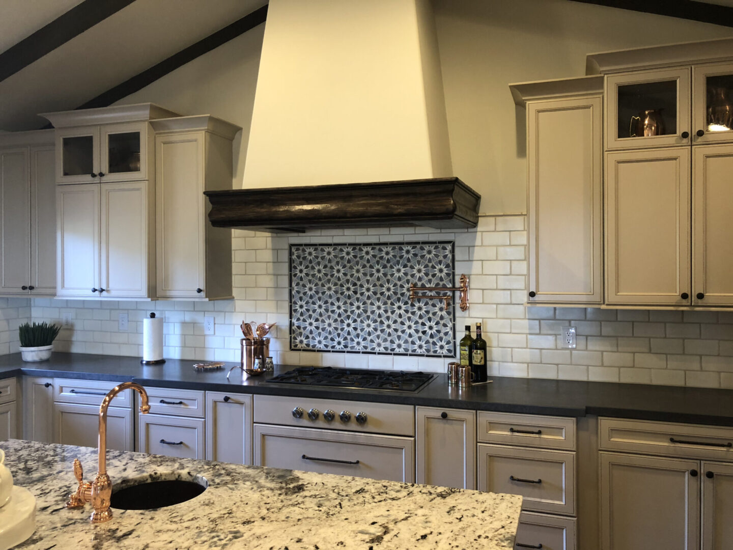 Kitchen with patterned tile backsplash and copper faucet