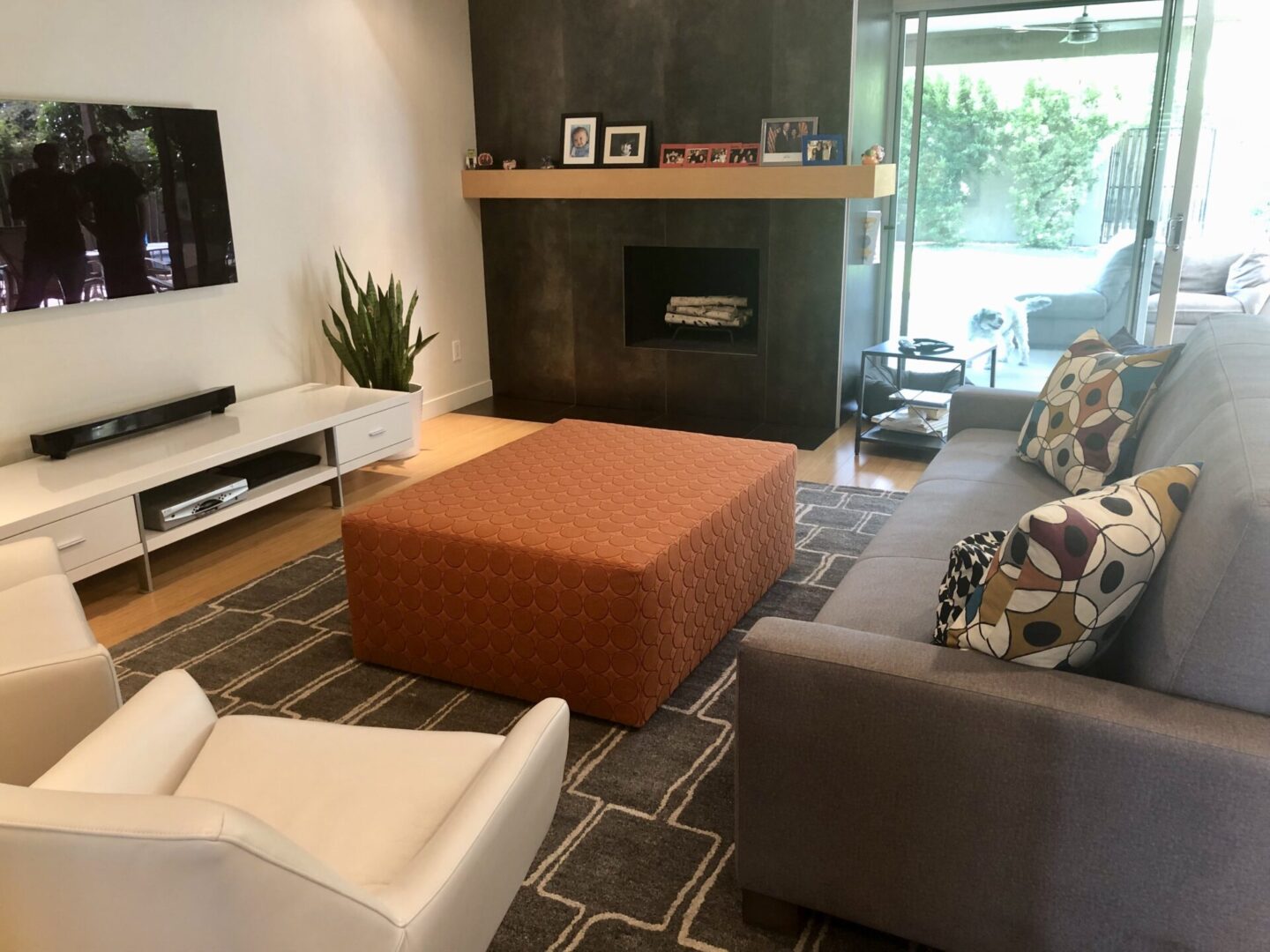 Modern living room with orange ottoman and sofa