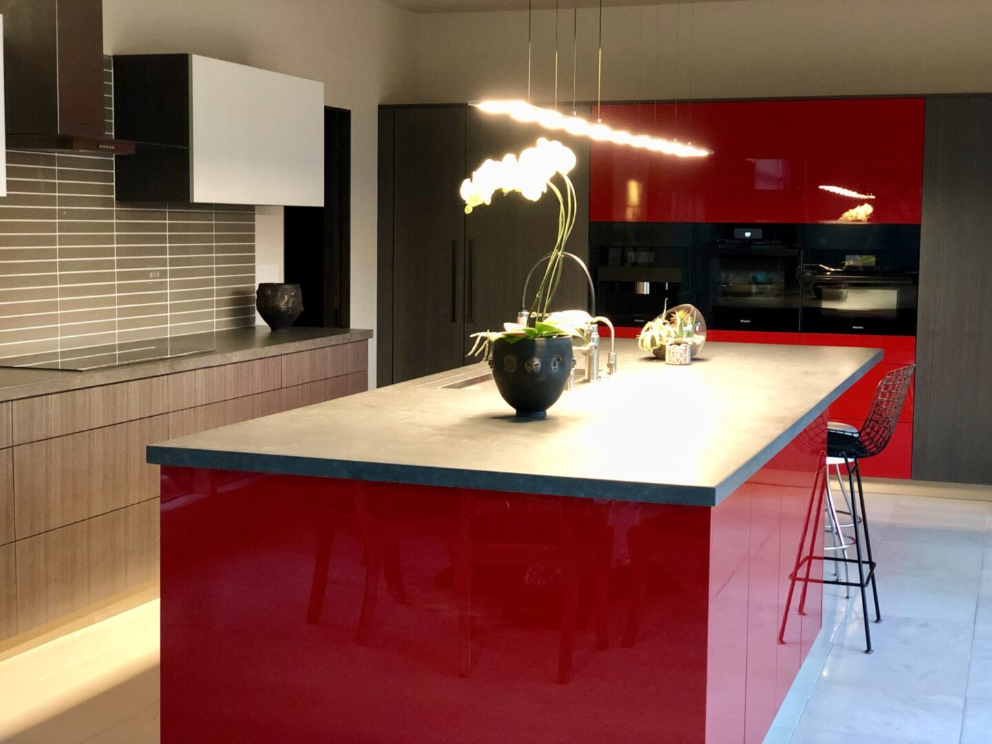 Modern kitchen with red island and stools
