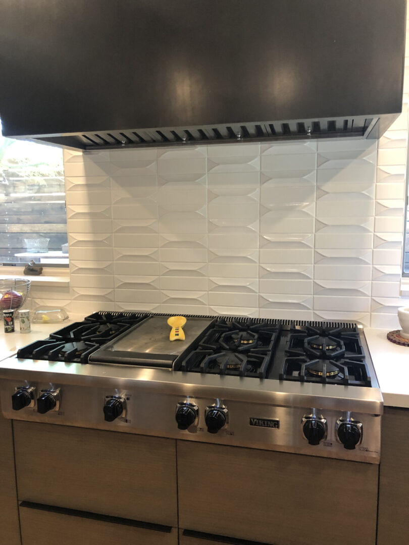 Stainless steel gas range with tiled backsplash