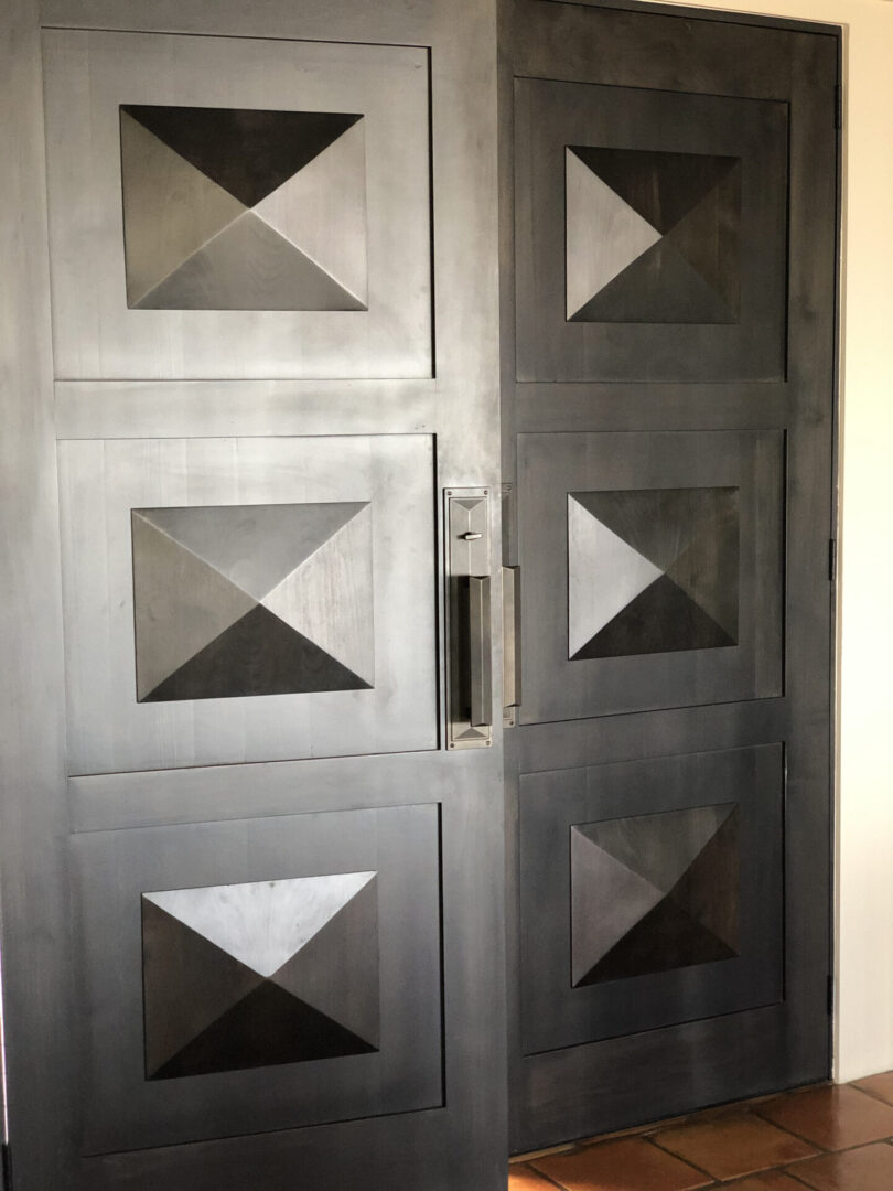 Double dark wood doors with geometric panels